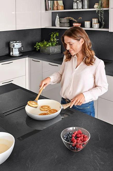 Cuisiner sur la table de cuisson avec hotte intégrée - une solution ergonomique pour plus d'espace pour la tête.