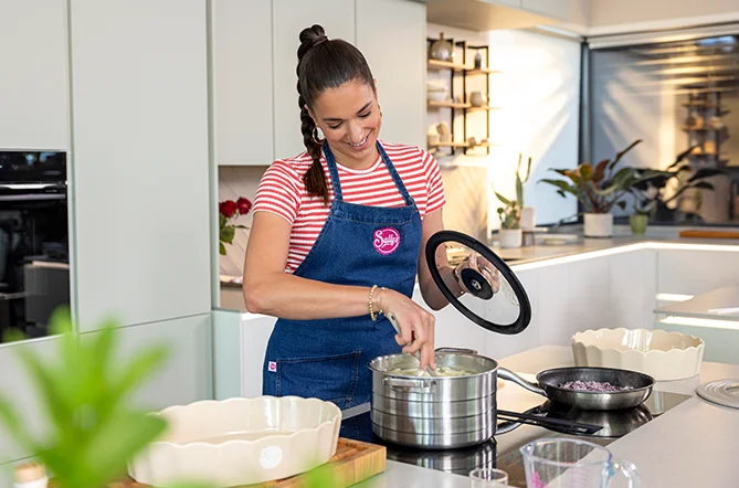 Moderne Wohnküche mit heller Frontgestaltung und großzügiger Kochinsel. Die Szene zeigt entspanntes Kochen im Alltag und liefert Inspiration für eine stilvolle, funktionale Küchengestaltung.