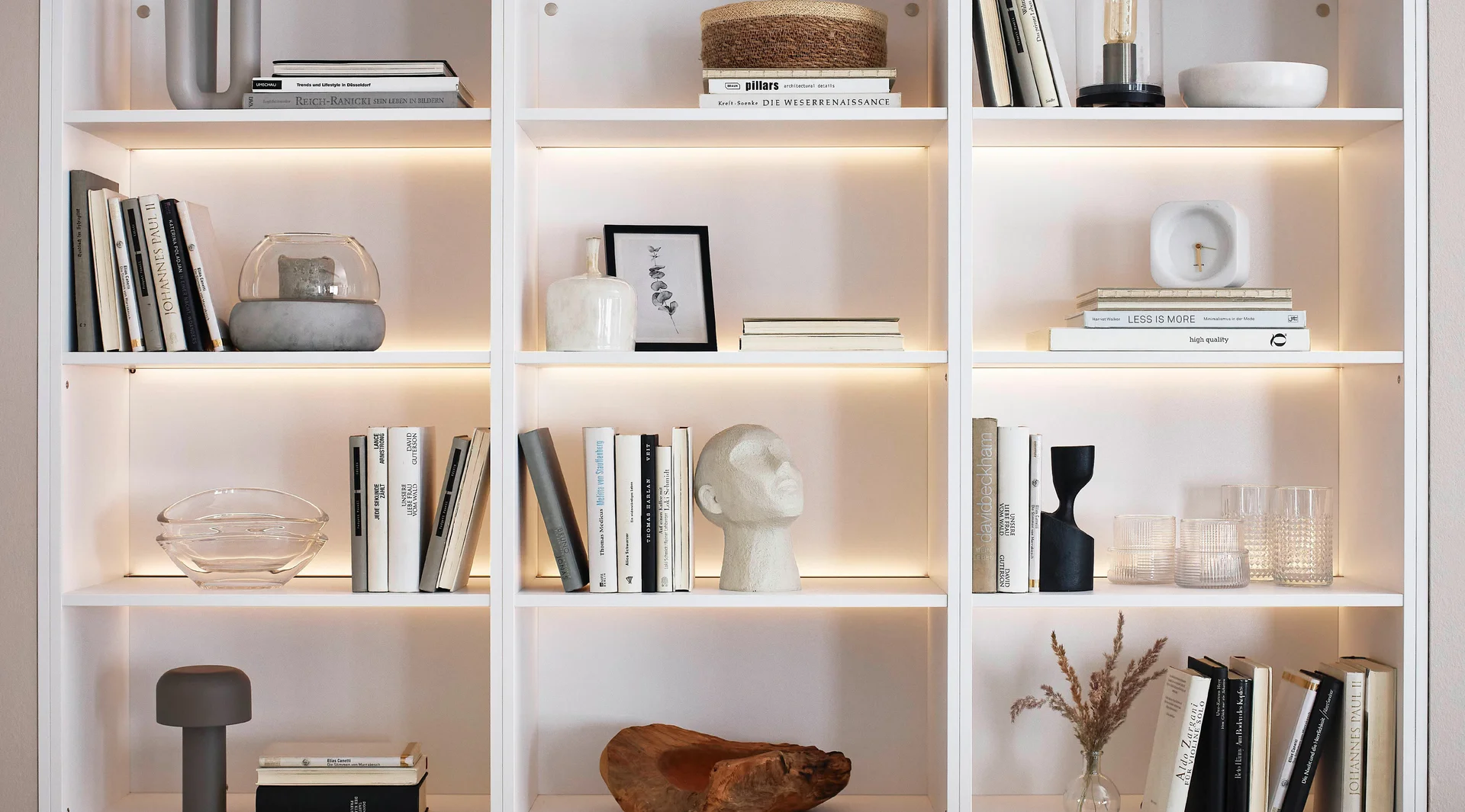 Étagère de salon éclairée avec des compartiments ouverts, une décoration de livres et un éclairage LED intégré.