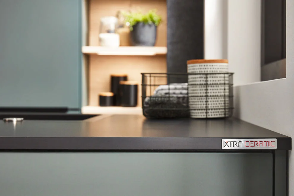 Le plan de travail Xtra Ceramic 790 Plain Black, associé à la façade Easytouch 964 vert minéral, ultra-mate.