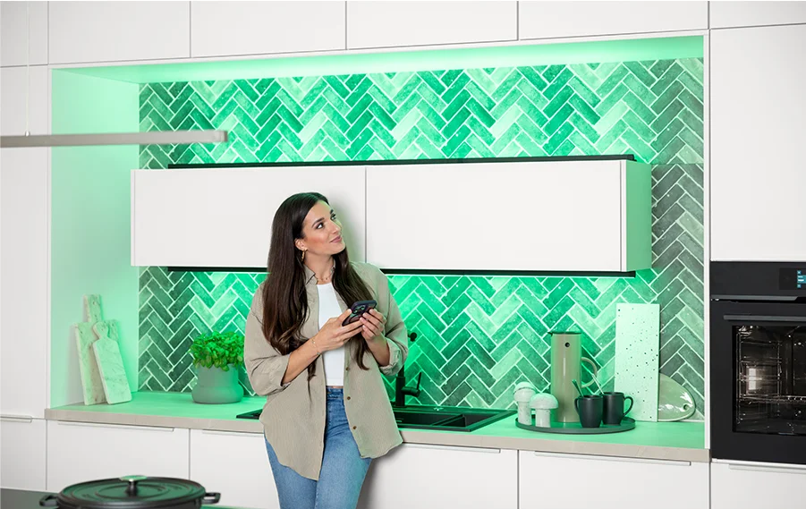 L'éclairage de cuisine avec Hue crée une ambiance dans une cuisine moderne grâce à une mise en scène lumineuse verte et à Sally.