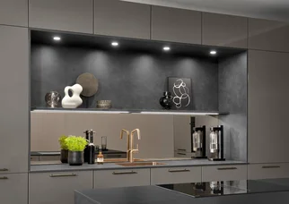 Luminaires LED encastrés et en saillie pour l'éclairage de cuisine dans une niche ouverte, assurant un éclairage homogène du plan de travail.