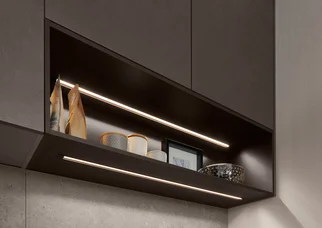 Luminaire LED encastré intégré pour l'éclairage de cuisine dans une armoire suspendue ouverte, offrant un éclairage homogène.