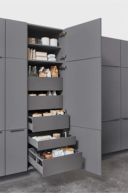 Armoire haute avec tiroirs intérieurs pour des provisions bien organisées. Un espace de rangement clair, moderne et facile d'accès.