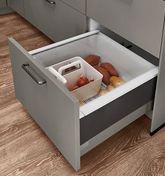 Cajón de cocina moderno que muestra una solución de almacenamiento organizada con un compartimento integrado para productos frescos como batatas y cebollas.