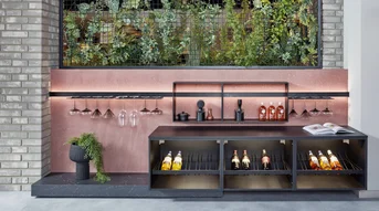Système de balustrades Sign Emotion avec éclairage dans l'espace de vie et casier à vin ouvert pour les bouteilles et les verres.
