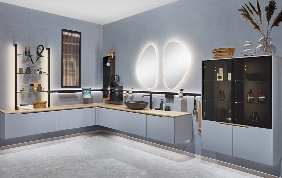 Cuisine moderne avec des façades grises, un plan de travail en bois et des éléments décoratifs élégants sur une étagère ouverte.