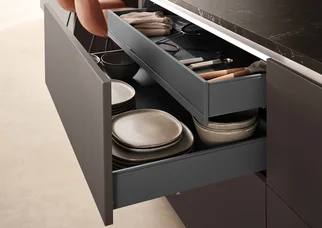 Tiroir « nBOX » dans la cuisine « Softline 505 », avec un espace de rangement bien organisé pour la vaisselle et les couverts dans le meuble bas.