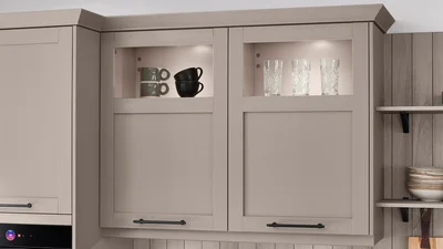 Wall units with glass frames and cornices set light accents in country house style.