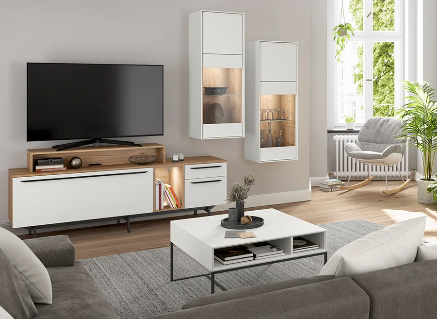 Nowoczesny wystrój salonu z dużym telewizorem z płaskim ekranem na drewnianym stoliku, przytulnym fotelu i eleganckimi dekoracjami dodającymi stylowej atmosfery.