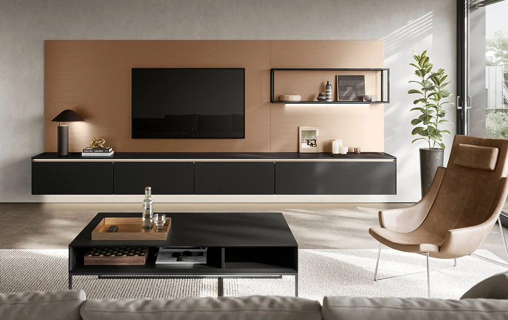 Wohnzimmer mit schwebendem Lowboard SENSO 496 in Schwarz und Antifingerprint-Fronten vor einer TV-Wand in Holzoptik