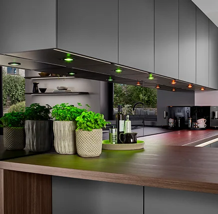 Concept d'éclairage intelligent avec Hue pour les cuisines, avec un éclairage coloré sous les éléments hauts et l'îlot de cuisine.