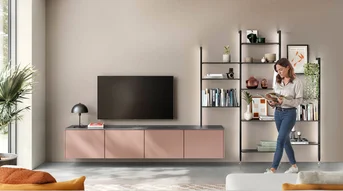 Salon couleur corail avec un système d'étagères en tunnel éclairé, un meuble TV et des étagères ouvertes dans l'espace de vie.