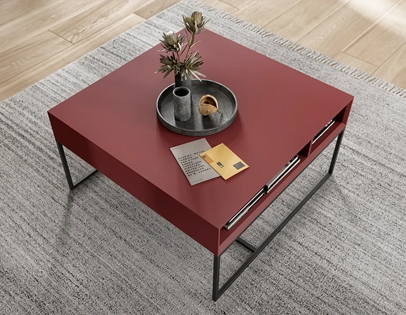 Elegancki nowoczesny czerwony stolik kawowy o minimalistycznym designie, z elegancką metalową ramą i ozdobną tacką z rośliną, ustawiony w przytulnym wnętrzu.